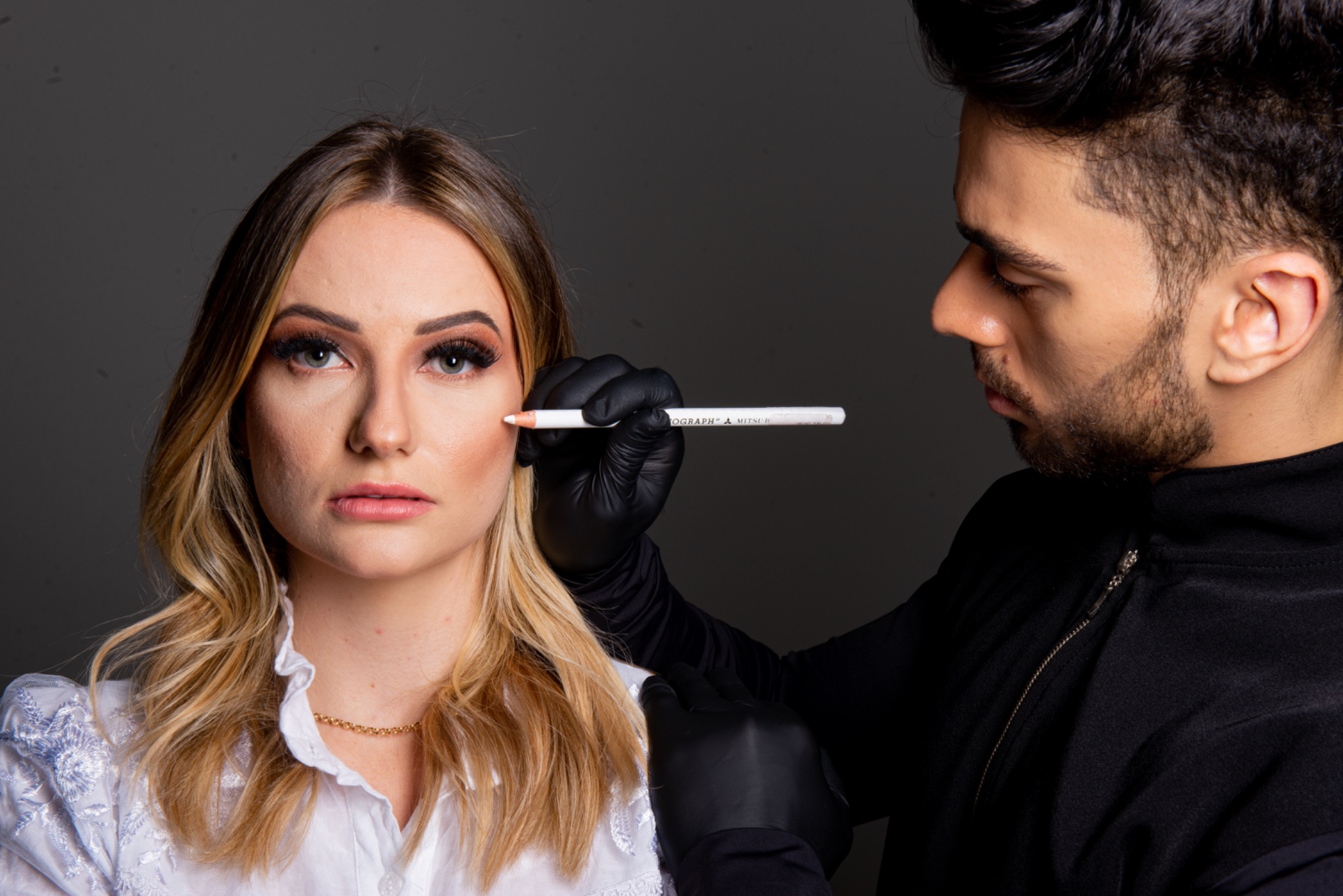 Yuri Peloi avaliando e marcando o rosto de uma paciente para planejamento facial